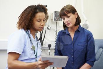 Nurse Showing Patient Test Results On Digital Tablet