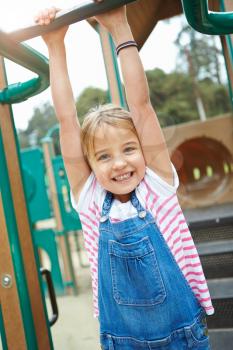 Young Girl On Climbing Frame In Playground