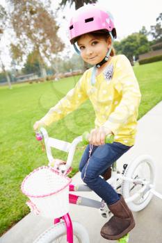 Young Girl Riding Bike In Park