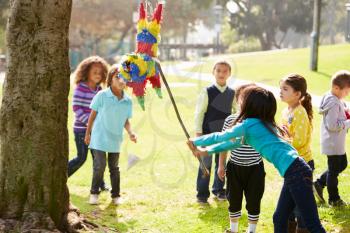 Children Hitting Pinata At Birthday Party