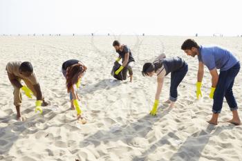 Group Of Volunteers Tidying Up Rubbish On Beach