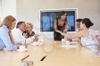 Businesswoman By Screen Addressing Boardroom Meeting