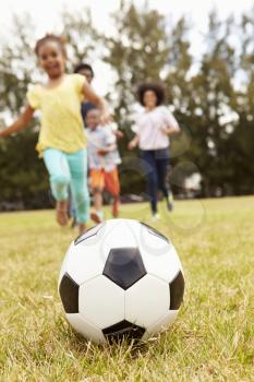 Family Playing Soccer In Park Together