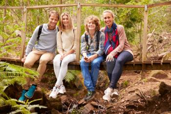 Portrait of family sitting on a bridge in a forest