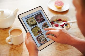 Person At Breakfast Looking At Recipe App On Digital Tablet