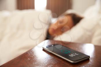 Woman Asleep In Bed Woken By Alarm On Mobile Phone