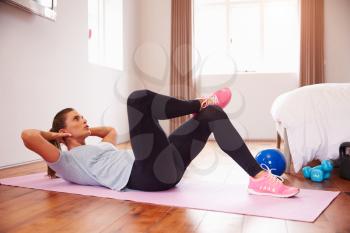 Woman Doing Fitness Exercises On Mat In Bedroom