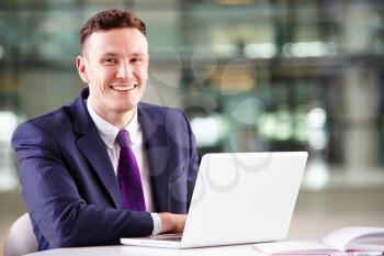 Young Caucasian businessman using laptop computer at work
