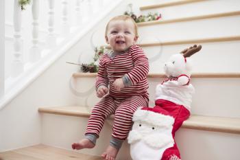 Young Girl On Stairs In Pajamas With Toy At Christmas