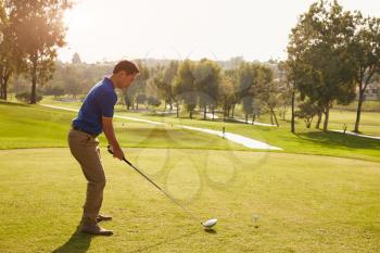 Male Golfer Lining Up Tee Shot On Golf Course