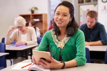 Asian woman in adult education class looking to camera