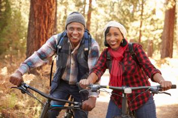 Portrait Of Senior Couple Cycling In Fall Woodland
