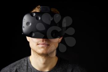 Young Man Wearing Virtual Reality Headset In Studio