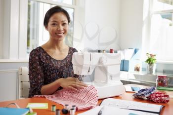 Woman Making Clothes Using Sewing Machine At Home