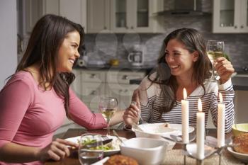 Female gay couple having a romantic dinner in their kitchen