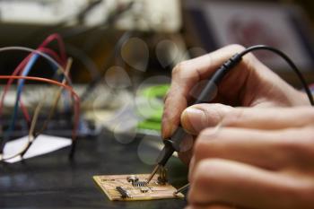 Close Up Of Electrical Engineer Soldering Circuit Board