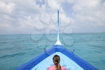 Back view of a woman sailing in a boat looking out to sea