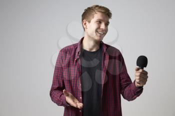 Studio Portrait Of Male Journalist With Microphone
