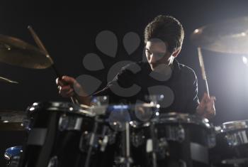 Young Drummer Playing Drum Kit In Studio