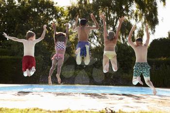 Rear View Of Children Jumping Into Outdoor Swimming Pool