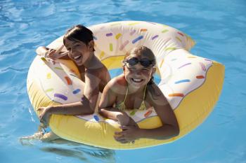 Children Having Fun With Inflatable In Outdoor Swimming Pool