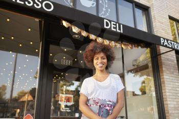 Black female business owner standing outside cafe shopfront