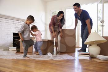 Family Unpacking Boxes In New Home On Moving Day