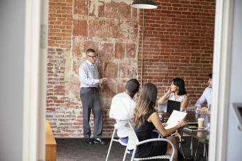 Businesspeople Meeting In Modern Boardroom Through Doorway