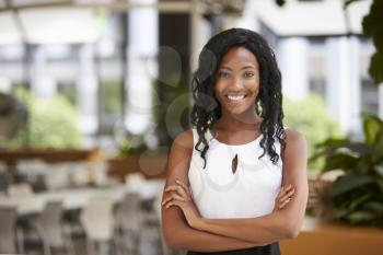 Smiling young black businesswoman with arms crossed