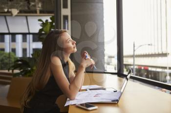 Businesswoman working in an office looking out of the window