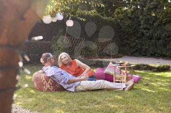Mature Couple Enjoying Drinks In Backyard Together