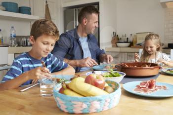 Father And Children At Home In Eating Meal Together