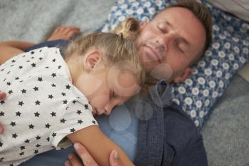 Father And Daughter Lying On Floor Asleep Together