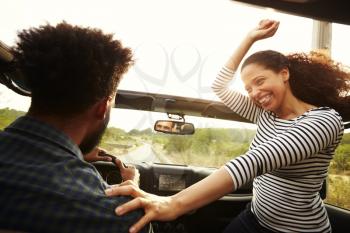 Man driving with excited woman passenger in front of car