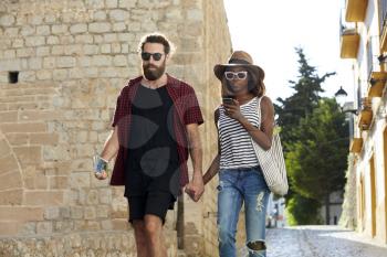 Couple on holiday walk, looking at phone, Ibiza, Spain