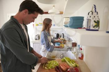 Young adult couple  preparing food, looking down