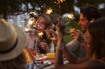 Friends With Sparklers Eating Food And Enjoying Party