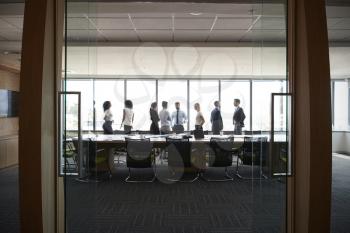 Businesspeople Stand And Chat Before Meeting In Boardroom