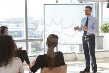 Businessman Making Presentation To Colleagues In Office