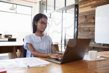 Young black woman working in office with laptop computer