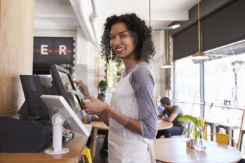 Portrait Of Waitress At Cash Register In Coffee Shop