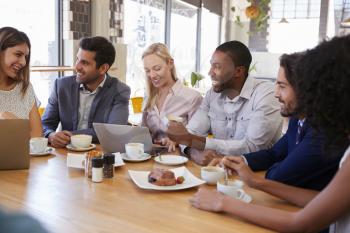 Group Of Businesspeople Having Meeting In Coffee Shop