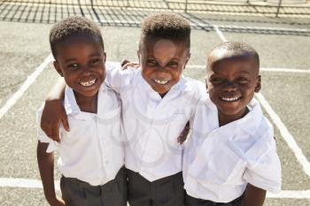 Young African schoolboys smiling to camera in a playground