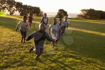 African elementary school kids running to camera in a field