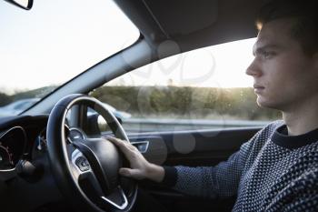 Interior View Of Young Man Driving Car On Motorway