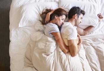 Overhead View Of Romantic Couple Lying In Bed Together