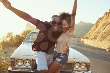 Portrait Of Young Couple Standing Next To Classic Car