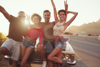 Portrait Of Friends Standing Next To Classic Car