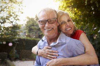 Portrait Of Loving Mature Couple In Back Yard Garden