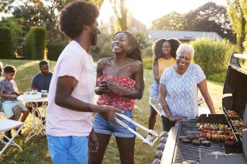 Couple laughing at a multi generation family barbecue